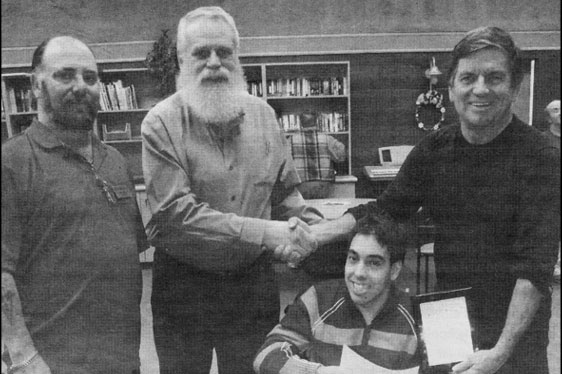 Two older men and Tony accepting a cheque from Garfield Dunlop