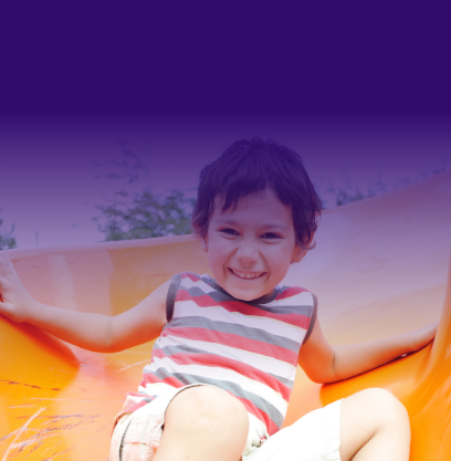 Un enfant joyeux glisse sur un toboggan jaune.