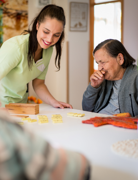 Une jeune femme et une femme âgée étalent des dominos sur la table.